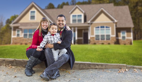 Happy Mixed Race Family in Front of Their Beautiful New Home.